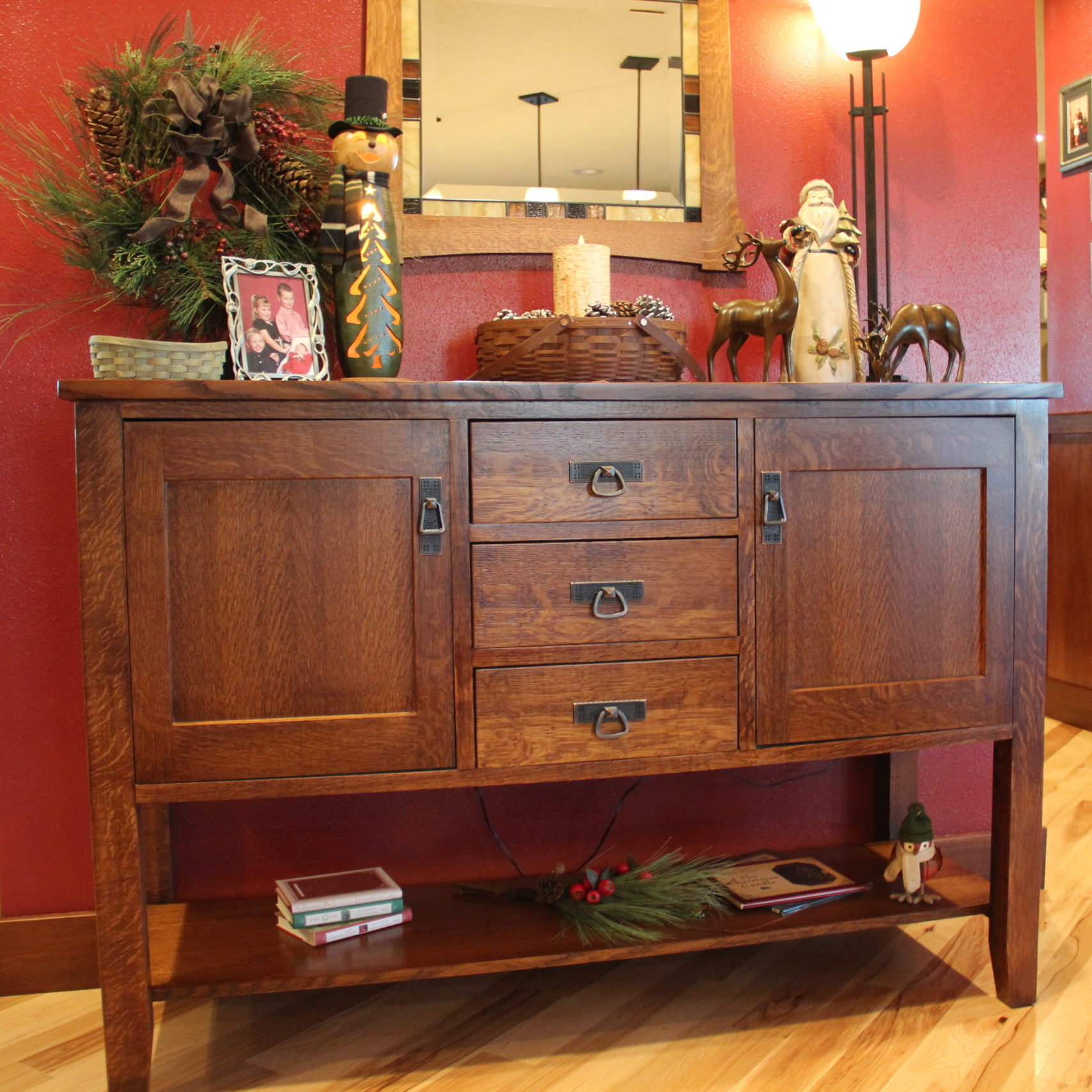 Sideboard full of fun. A Longaberger basket with birch automatic flicker candle surrounded by snowy pinecones. A tall wood Santa with reindeer and for the other side a wreath created at a floral shop in town, a snowman gourd a favorite Christmas pic of the Waite Kids.