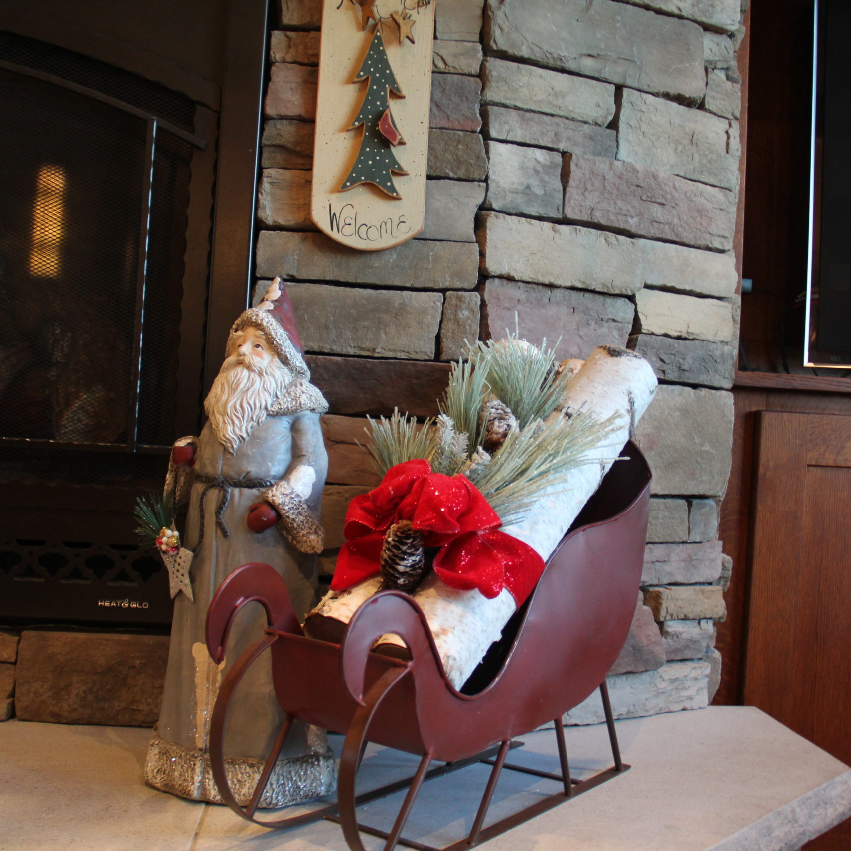 On the hearth I choose a nice tall Santa from a shop in Galena. The sleigh is Pottery Barn and the birch logs from the floral shop in town. I added a greenery stick in frosty pine with a bright red velvet ribbon.
