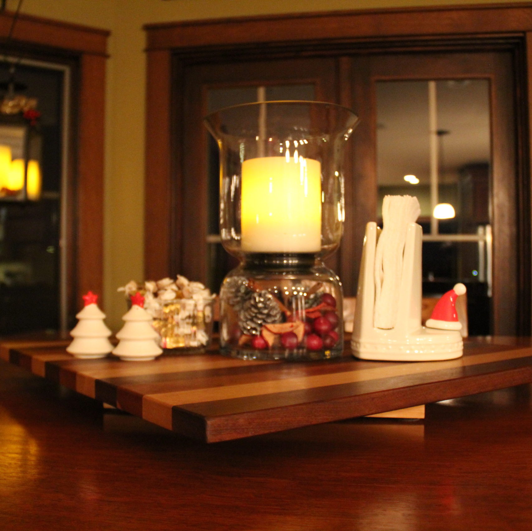 For the kitchen tabletop I change out the hurricane fillings to something more seasonal. The Nora Fleming napkin holder gets a cut Santa hat mini and then a change in salt and pepper shakers.