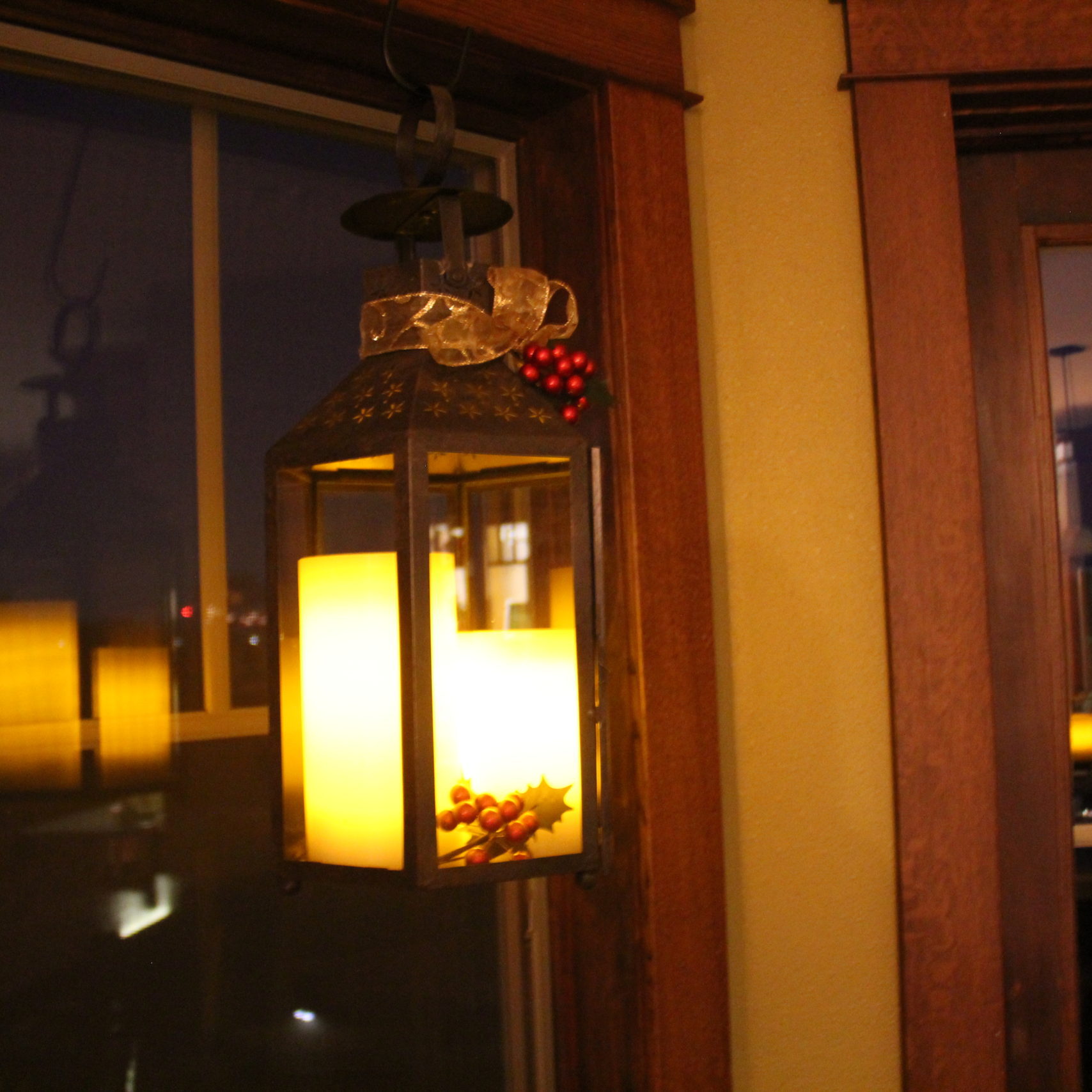 I like dressing up my lanterns for the holiday. Giving them a bow tie and glowing candles with springs of holly.