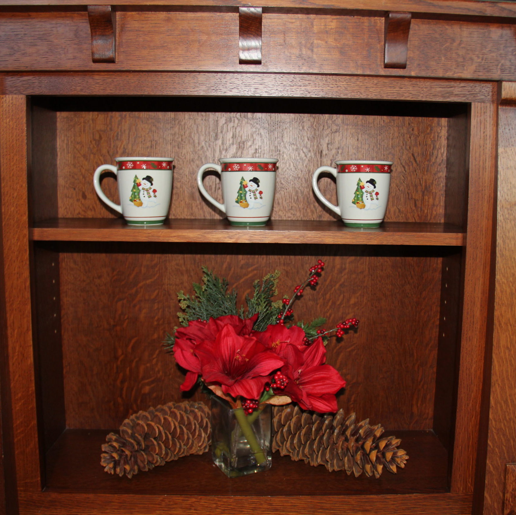 Longaberger Christmas pottery and a floral arrangement by Pottery Barn with giant pinecones to accent