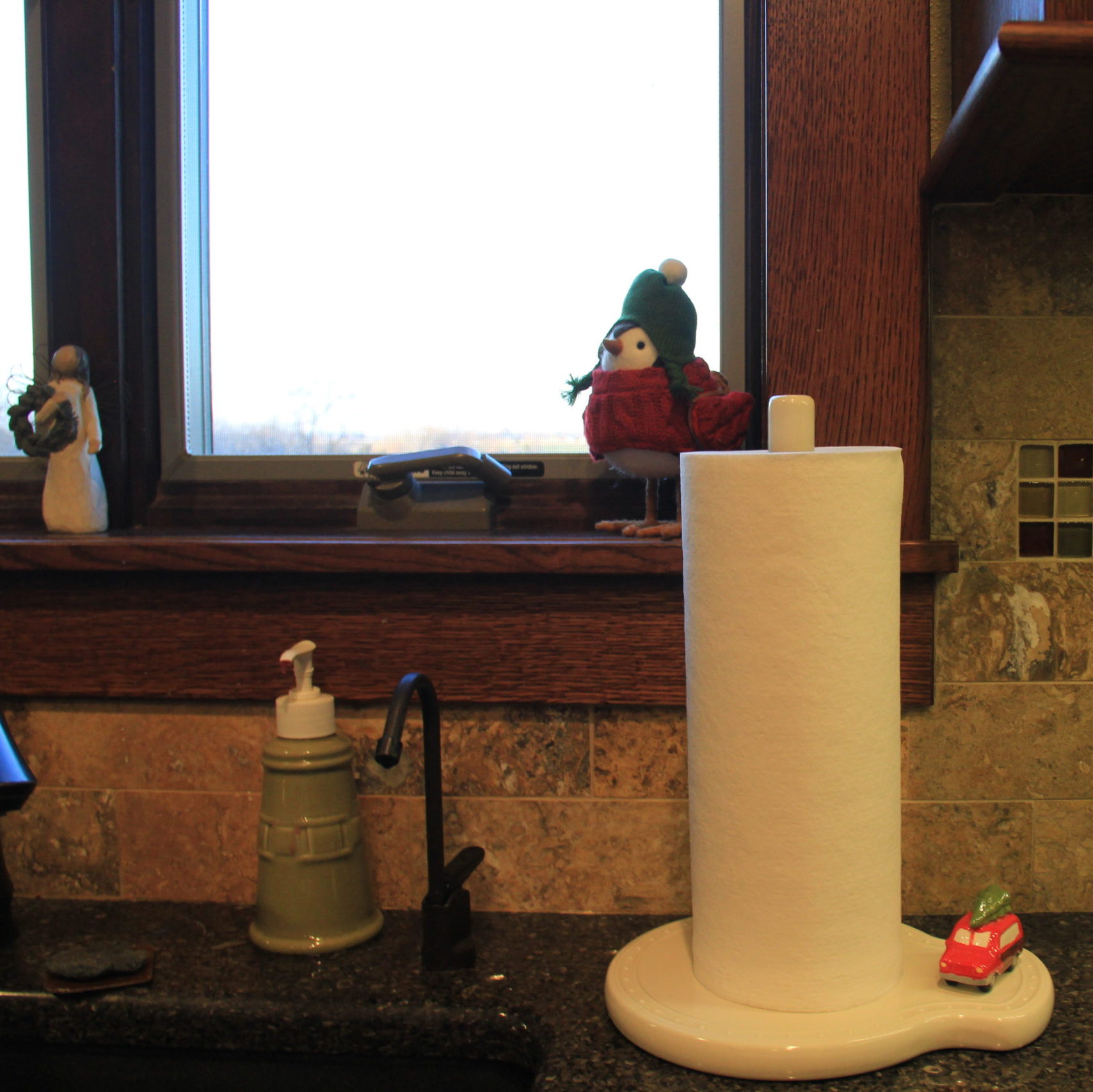 Nora Fleming paper towel holder with cute Woody Mini, winter bird and Angel of Winter add holiday to my kitchen sink.