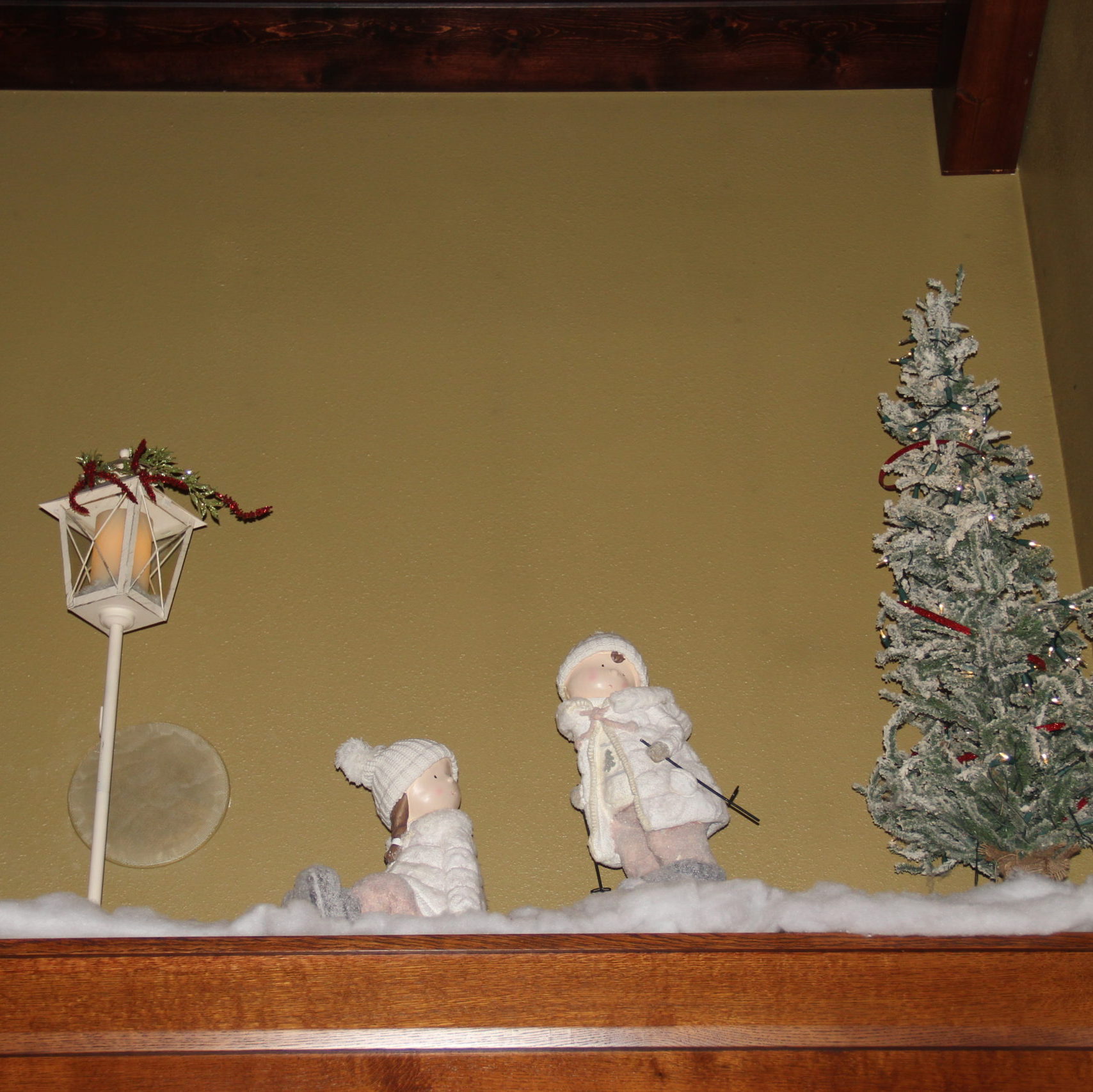 The tiptop of the built ins in the great room are fun to decorate. I found the kid statues in Galena at a shop and they are just the right scale. The lantern wrapped with a tree pick and the flocked pine from Earthly Blessings in town complete this side.