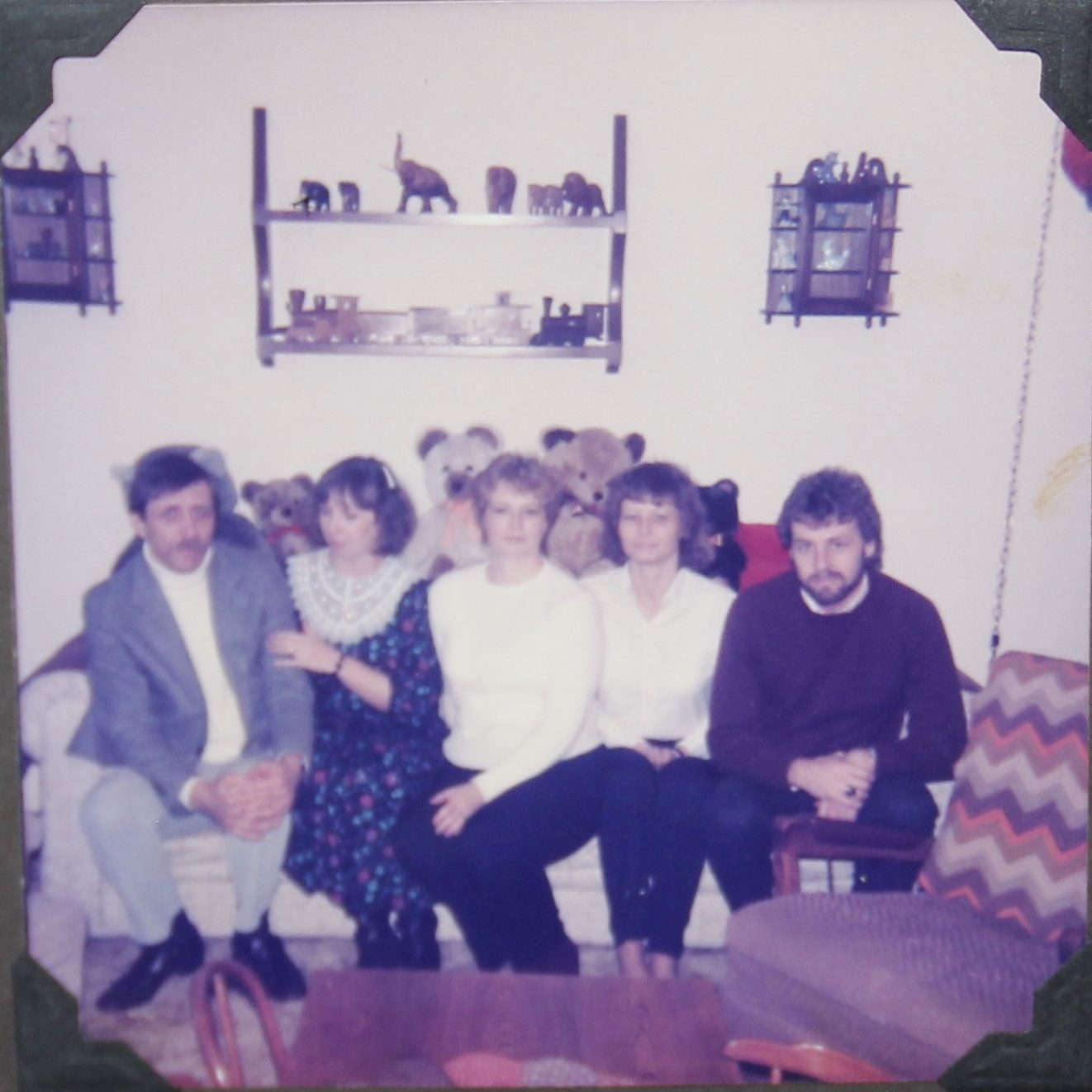 Cora Fishers grandchildren on the teddy bear couch with elephants above.