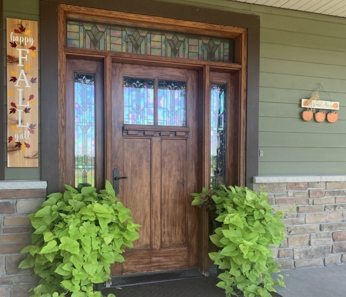 Our front door is flanked by two self watering pots overflowing with a mix of potato vine. New this year is the Happy Fall sign made for me by our daughters and then the pumpkin patch with a welcome message.